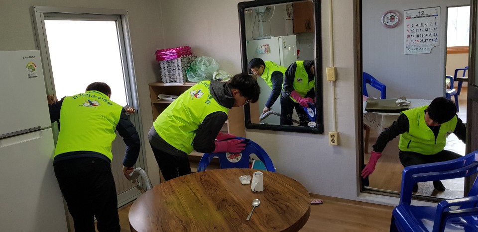 울진군선관위 직원과 공정선거지원단이 마을회관 실내를 쓸고 닦으며 청소하는 모습입니다.